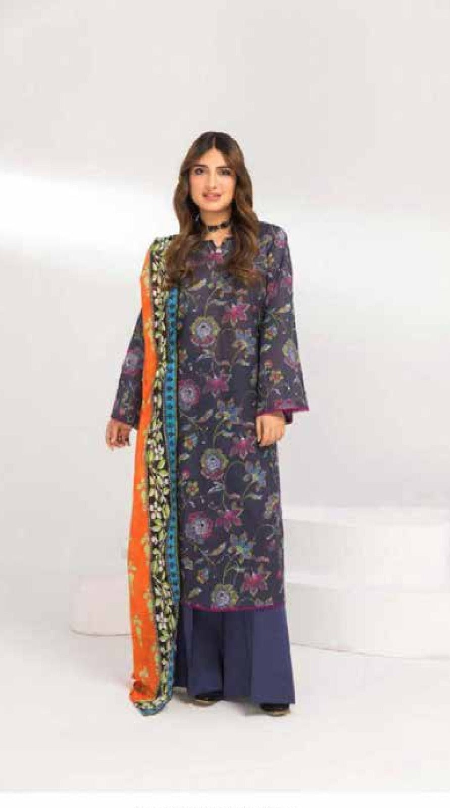 Woman wearing a floral kurta with a colorful dupatta on a white background