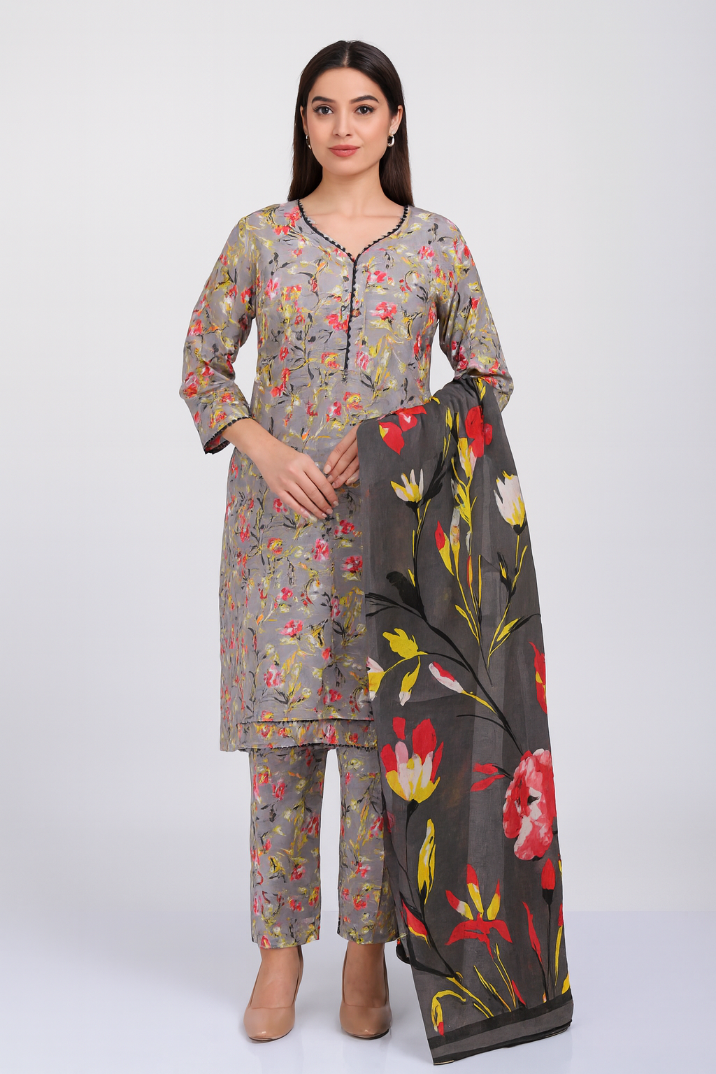 Woman wearing a floral kurta with pants and a matching dupatta on a white background