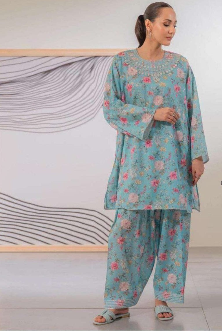 Woman wearing a floral outfit standing against a minimalistic background