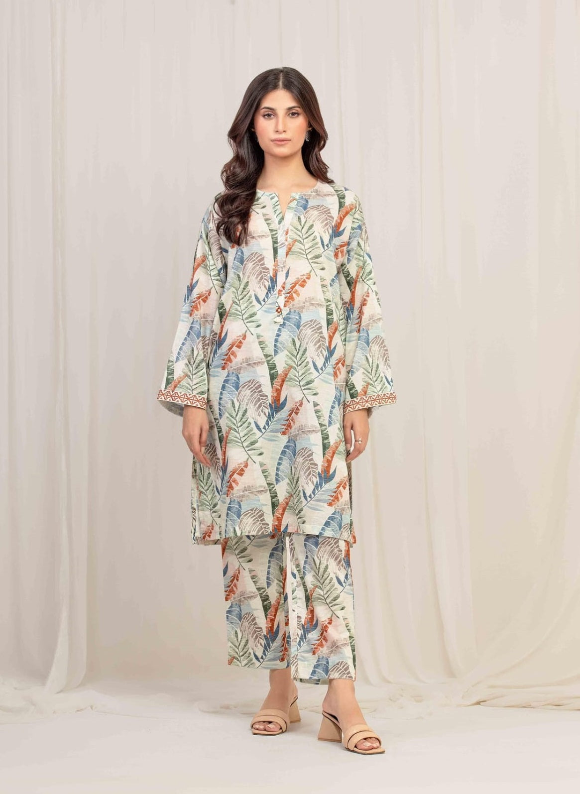 Woman wearing a floral print outfit against a white background