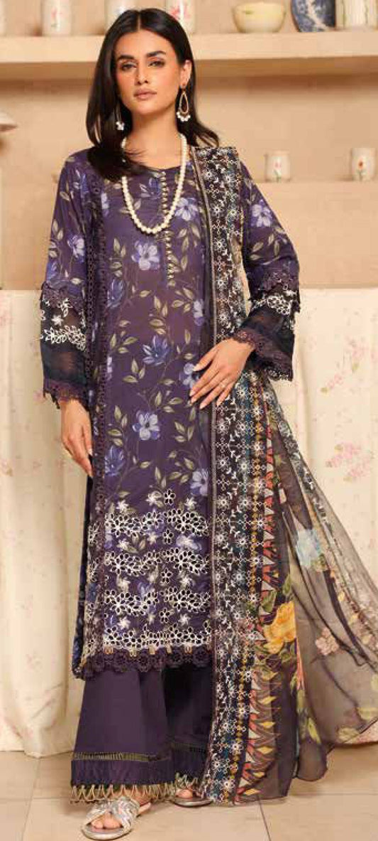 Woman wearing a floral purple outfit with a matching dupartta in a decorated room.