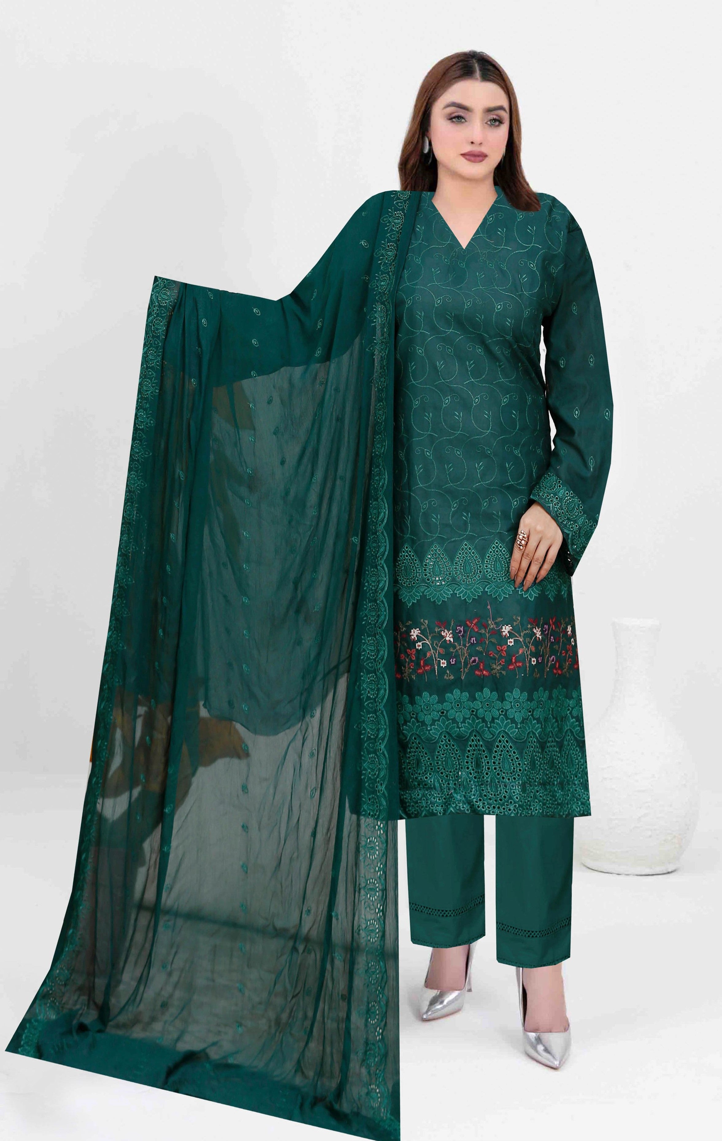 Woman wearing a green embroidered outfit with a dupatta on a white background