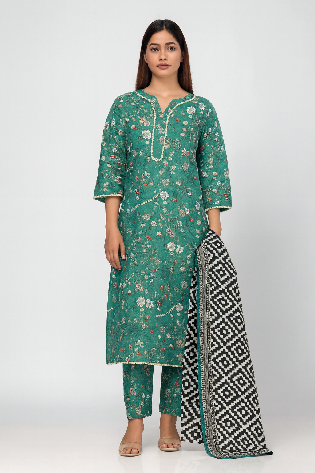 Woman wearing a green floral kurta with matching Trouser and a black and white patterned dupatta on a white background