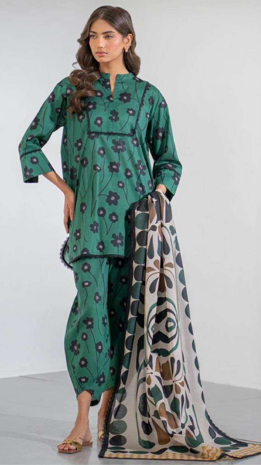 Woman wearing a green floral traditional outfit with a patterned trouser on a white background
