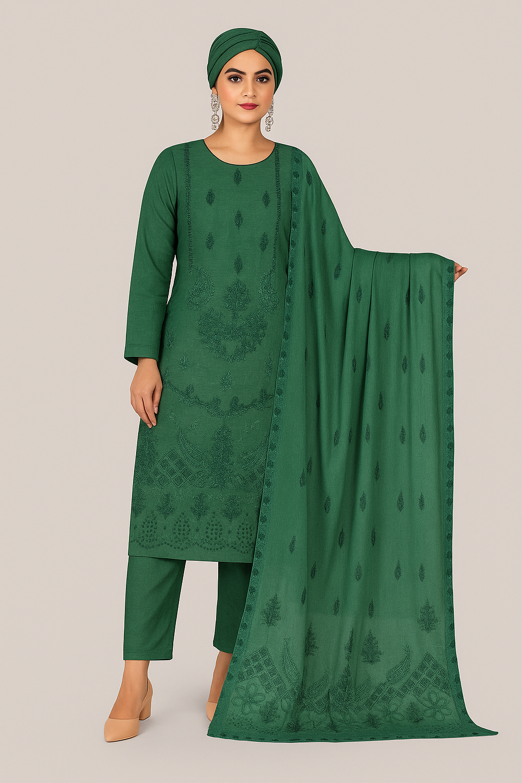 Woman wearing a green traditional outfit with a matching dupatta on a beige background