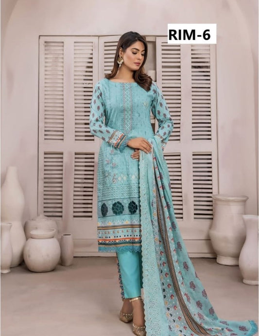 Woman wearing a light blue embroidered outfit with a matching dupatta in a minimalistic setting.