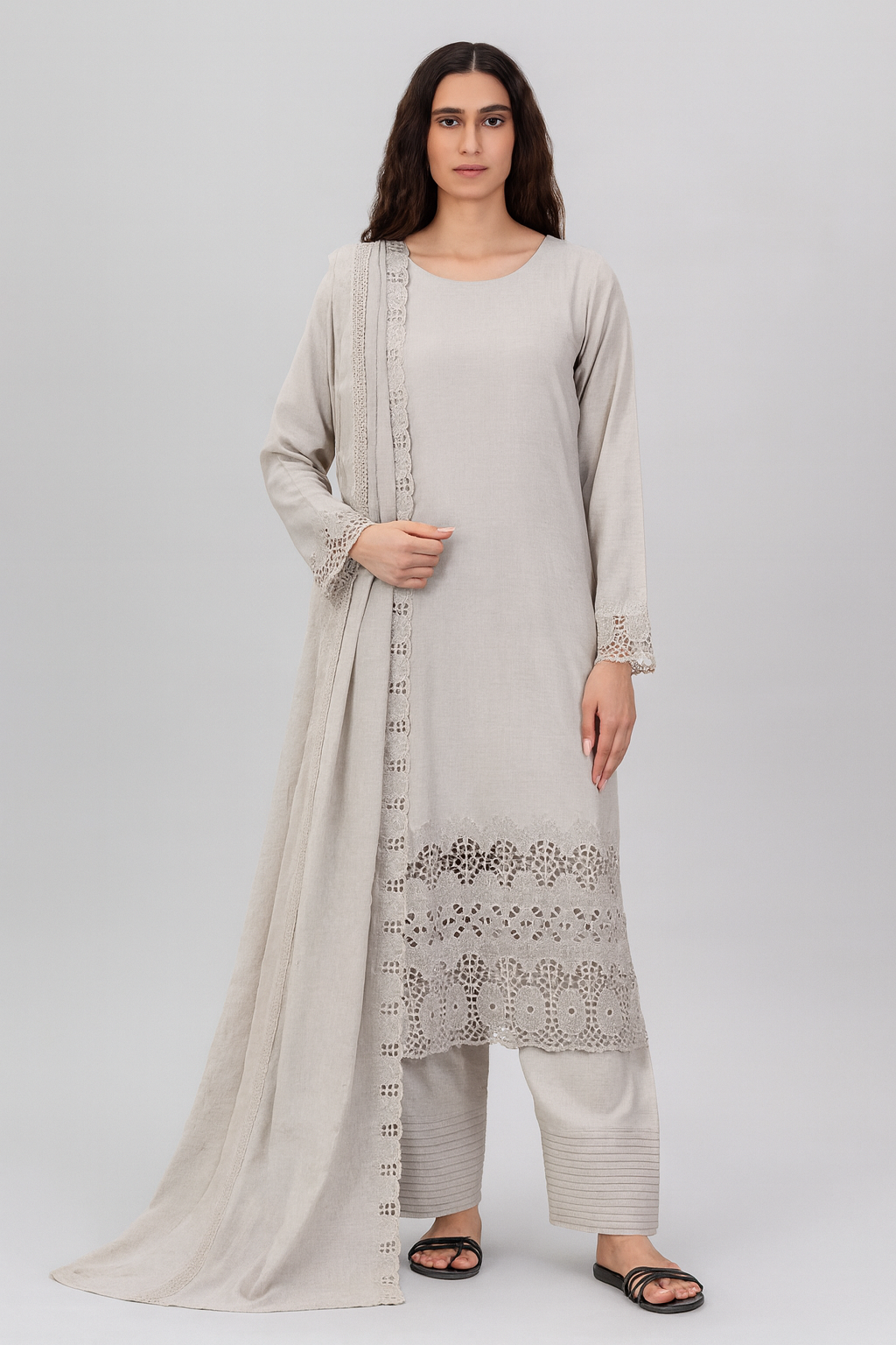Woman wearing a light gray traditional outfit with a matching dupatta on a white background