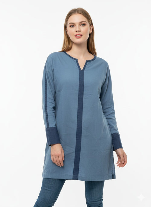 Woman wearing a long blue tunic with a white background