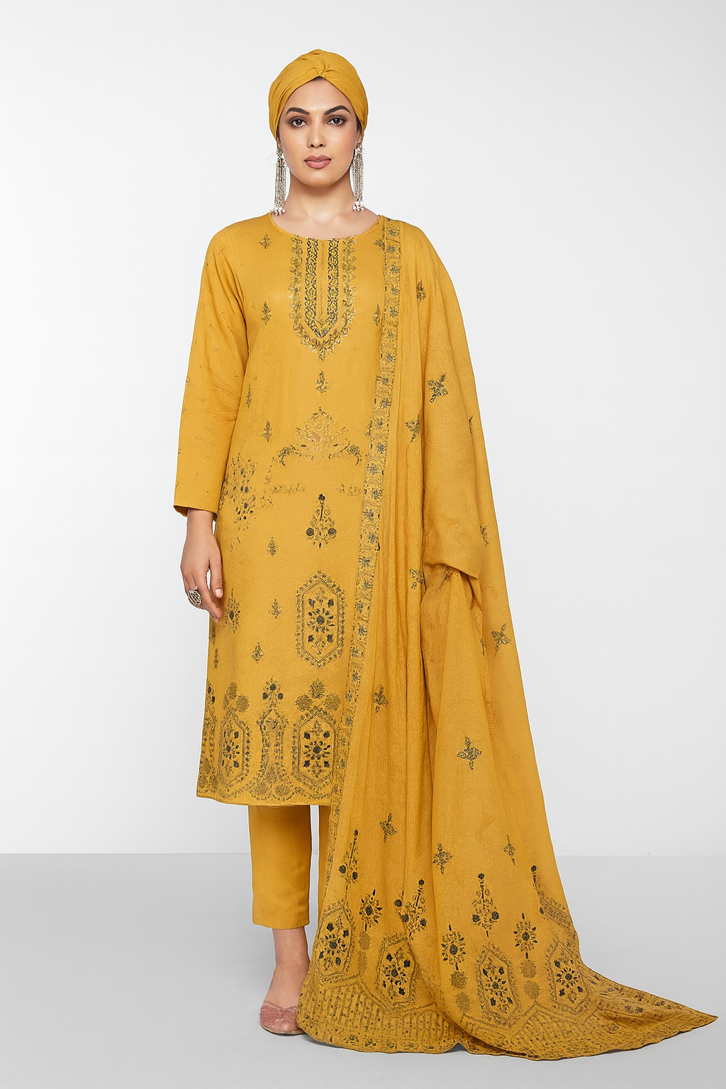 Woman wearing a mustard yellow embroidered outfit with a matching dupatta on a white background