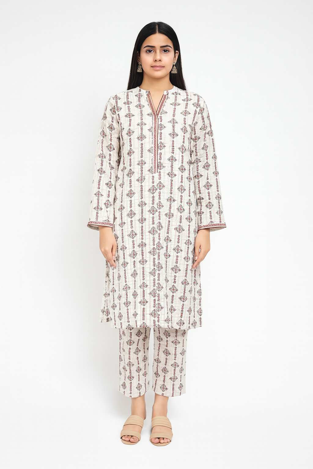 Woman wearing a patterned kurta with matching pants on a white background