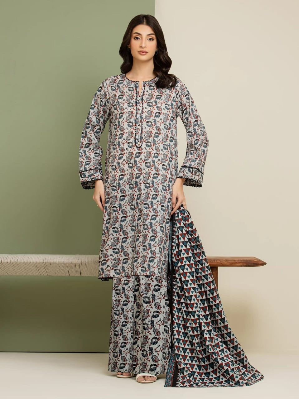Woman wearing a patterned kurta with matching pants against a neutral background