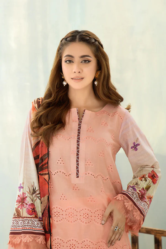 Woman wearing a peach-colored embroidered outfit with floral patterns against a light background