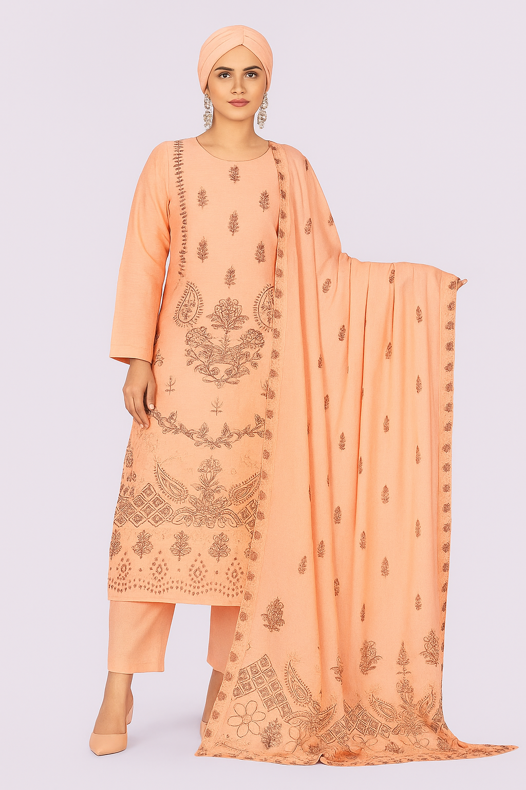 Woman wearing a peach embroidered outfit with a matching dupatta on a light gray background