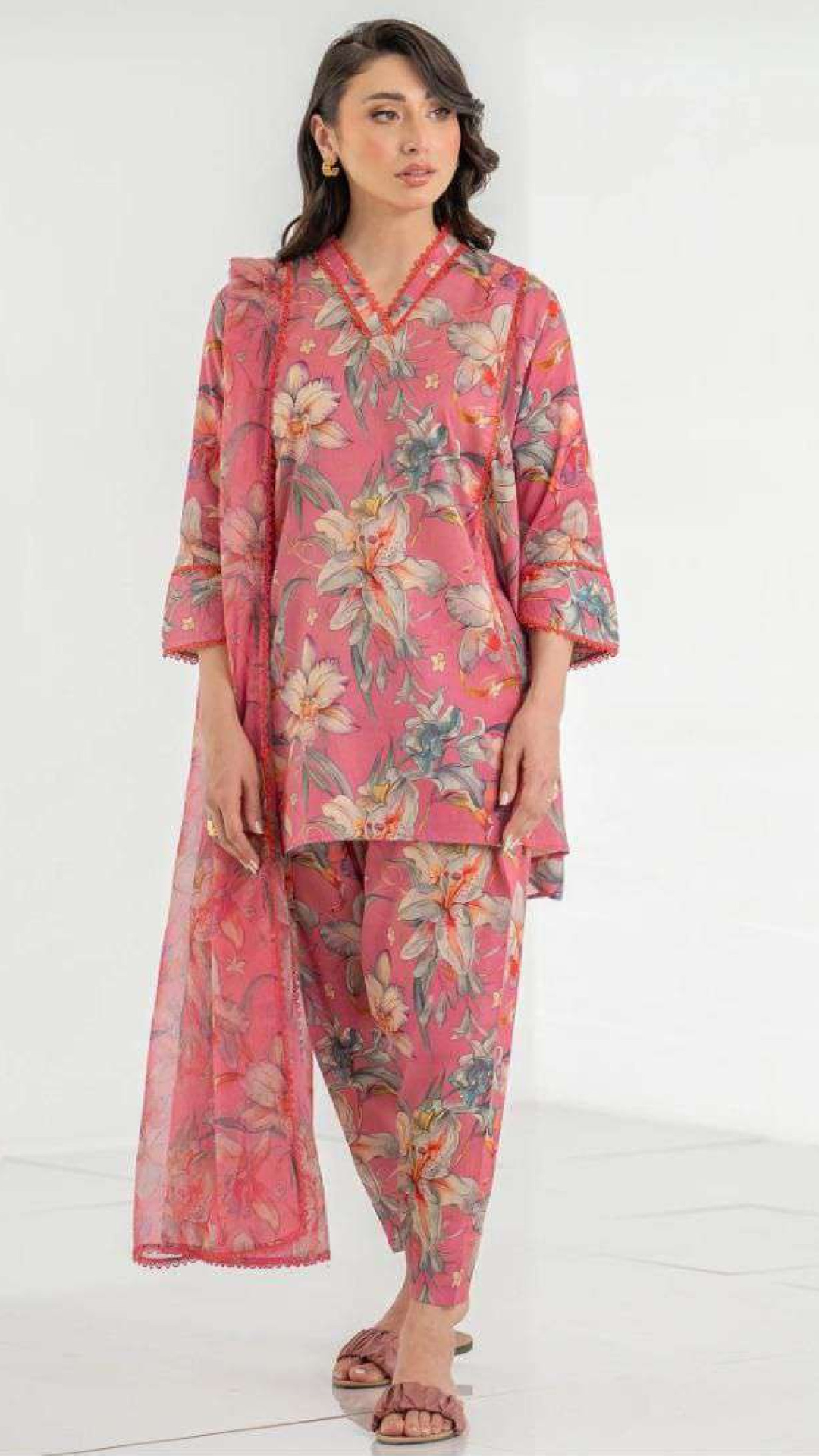 Woman wearing a pink floral outfit on a white background