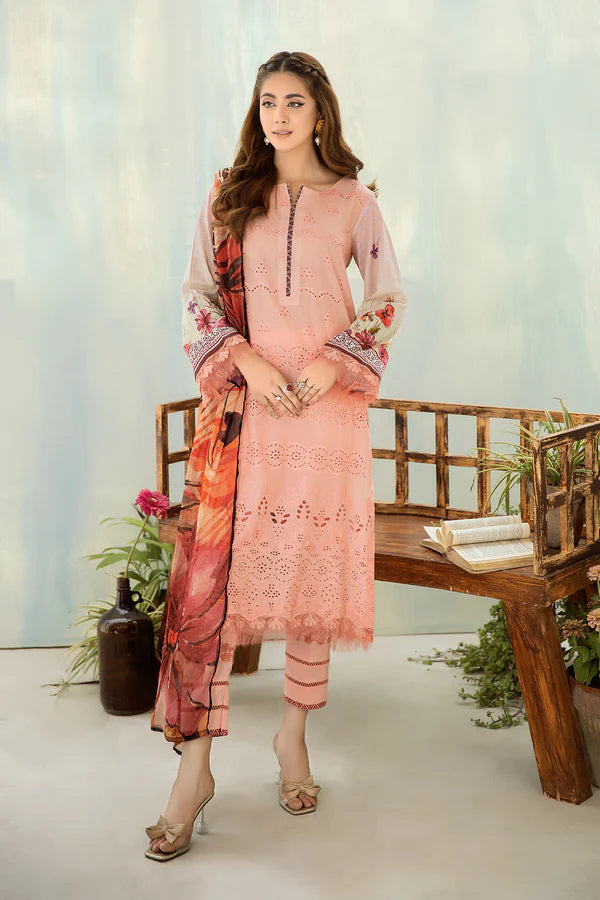 Woman wearing a pink traditional outfit with floral patterns in a minimalistic setting.