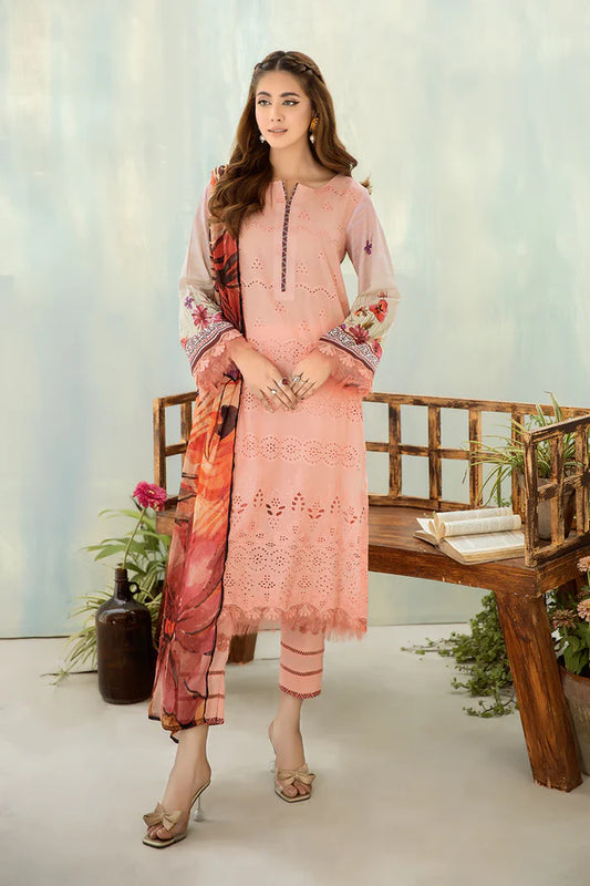 Woman wearing a pink traditional outfit with floral patterns in a minimalistic setting.
