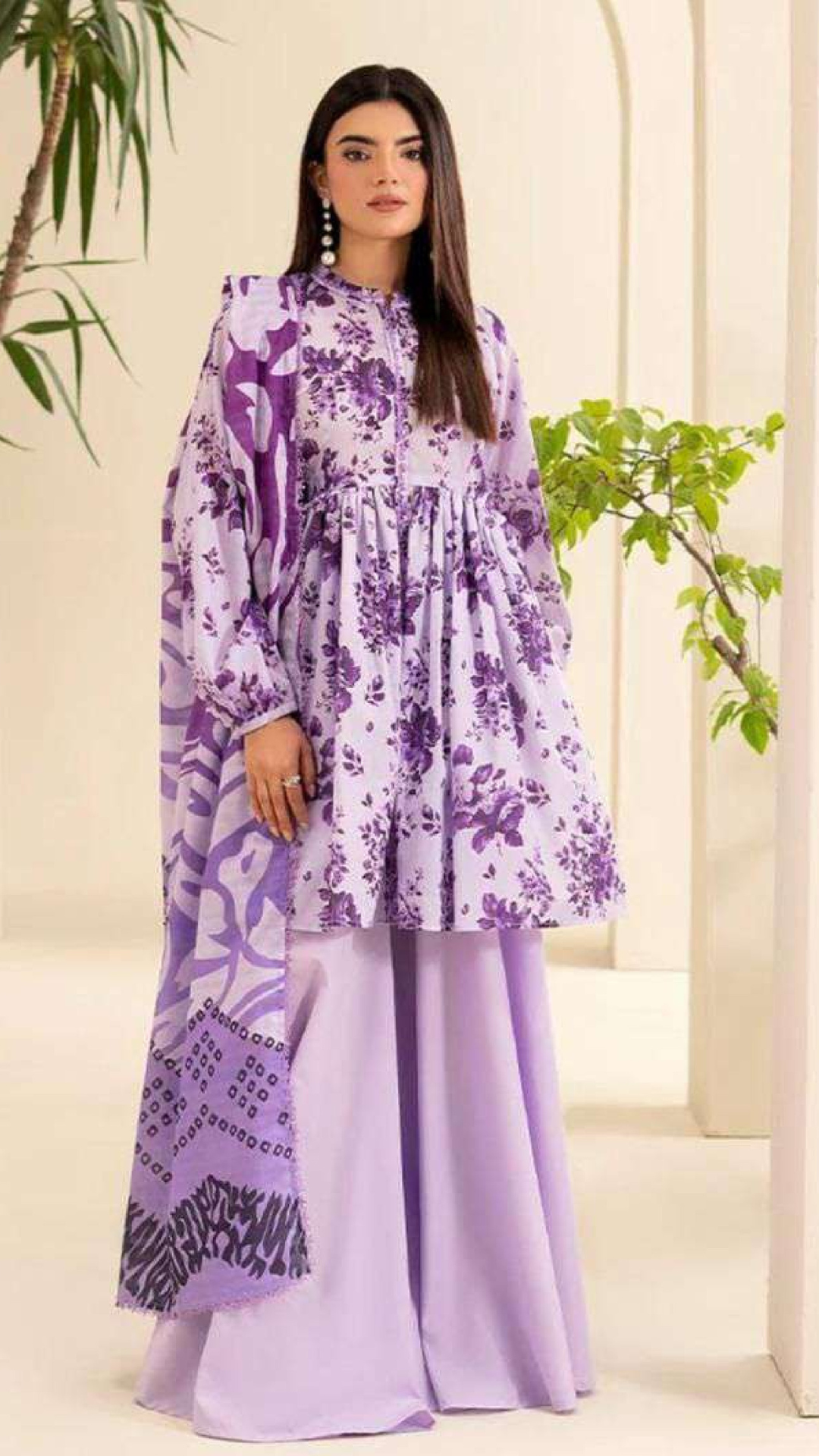 Woman wearing a purple floral outfit with a white background