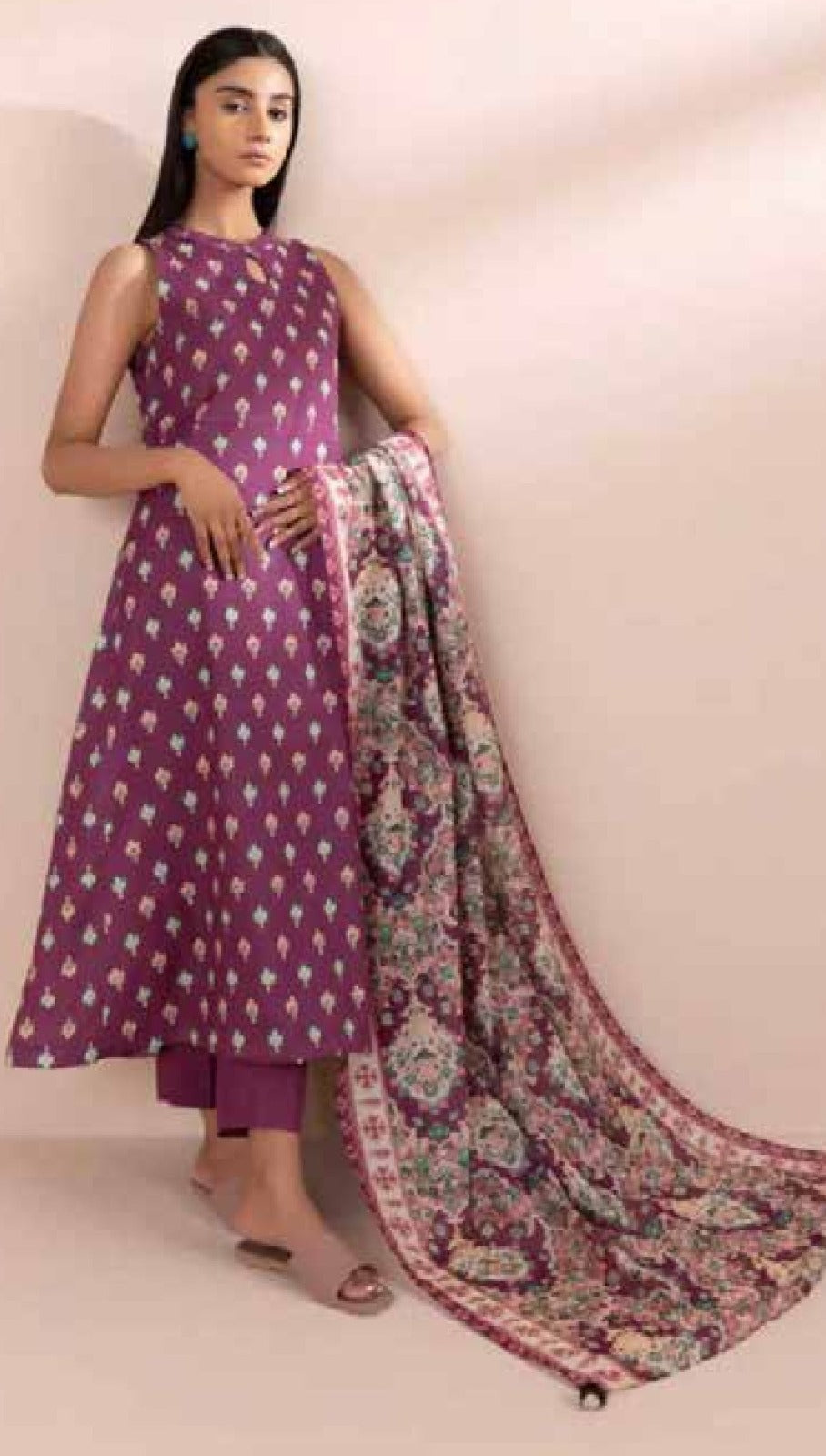 Woman wearing a purple traditional outfit with a floral dupatta on a beige background
