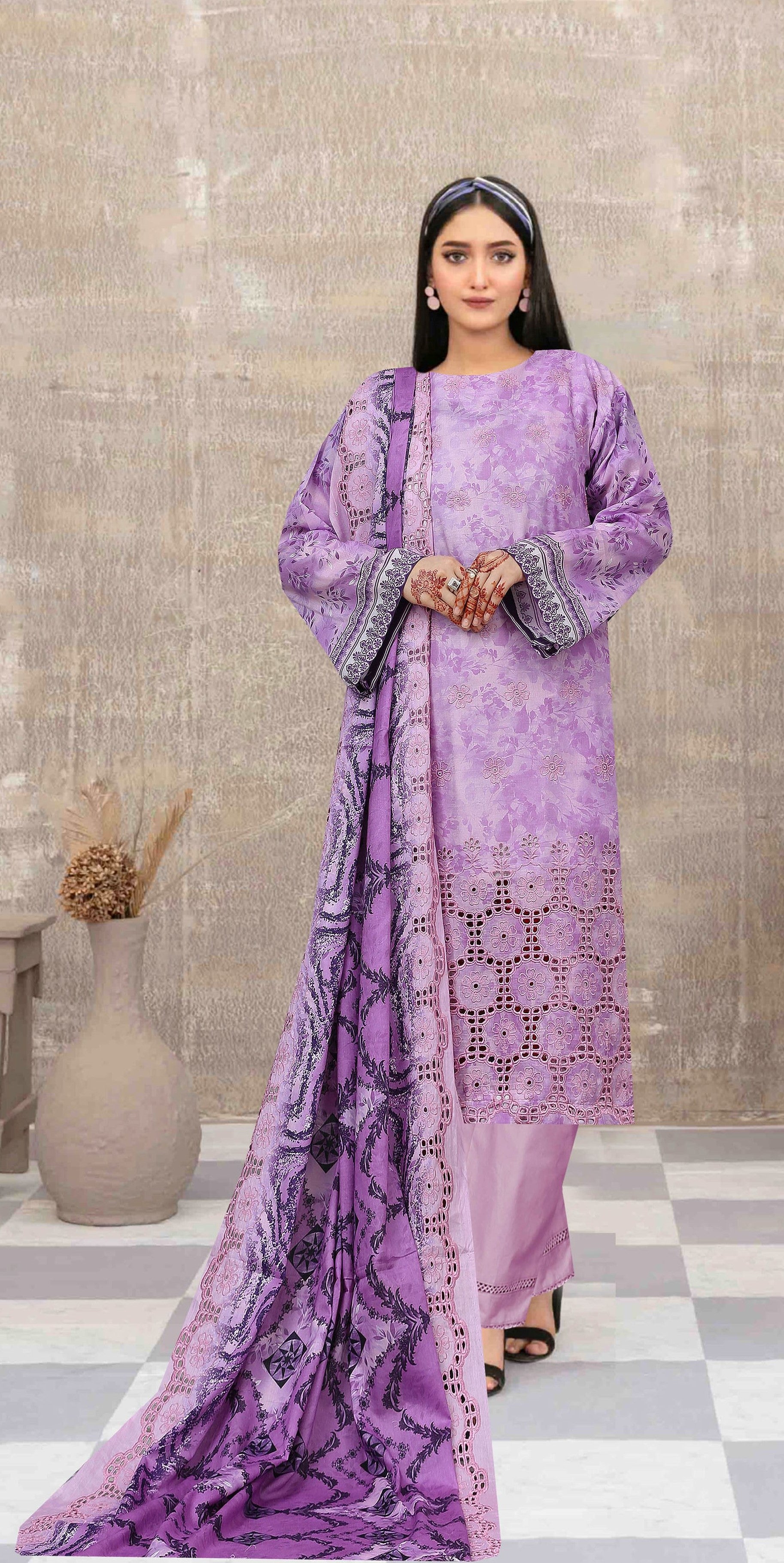 Woman wearing a purple traditional outfit with a matching dupatta in an indoor setting.