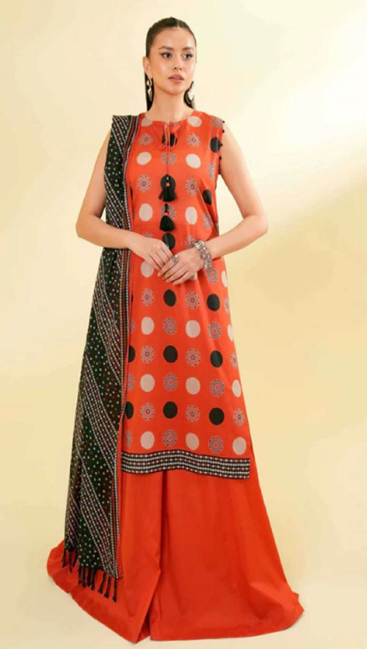 Woman wearing a red dress with a black and white patterned dupatta on a beige background