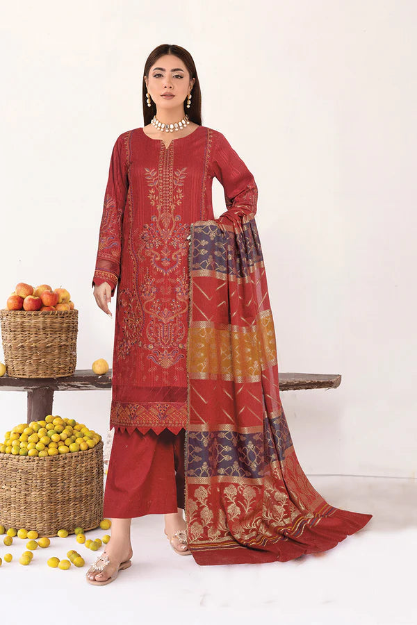 Woman wearing a red embroidered traditional outfit with a matching dupatta, standing next to a table with fruits.