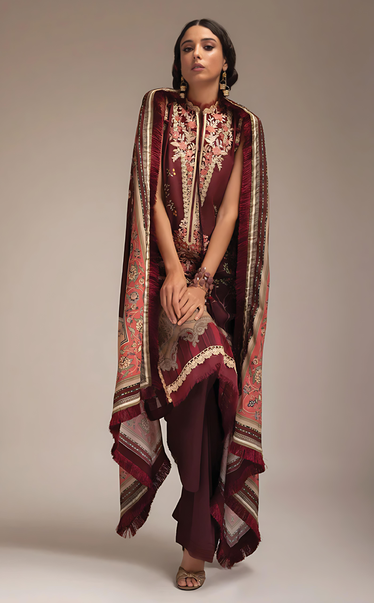 Woman wearing a sobia nazir printed outfit with a matching dupatta on a beige background