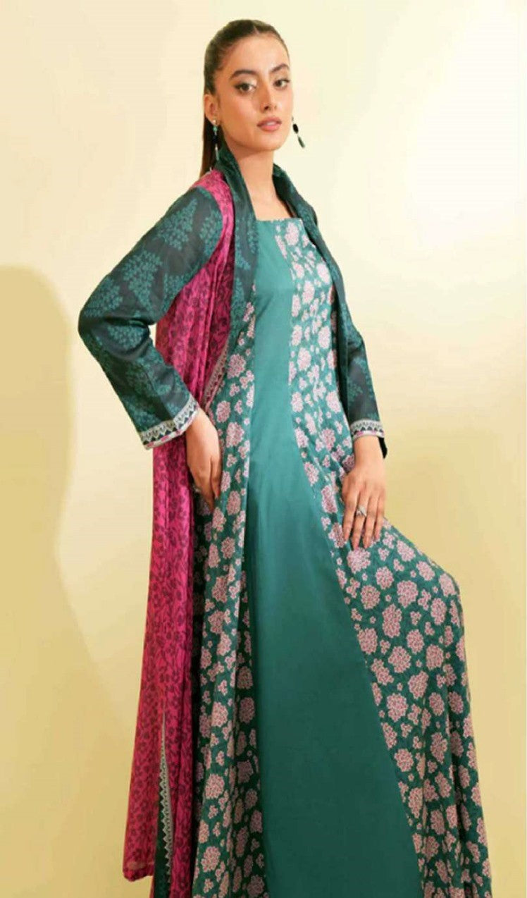 Woman wearing a teal dress with floral patterns and a matching dupatta on a beige background