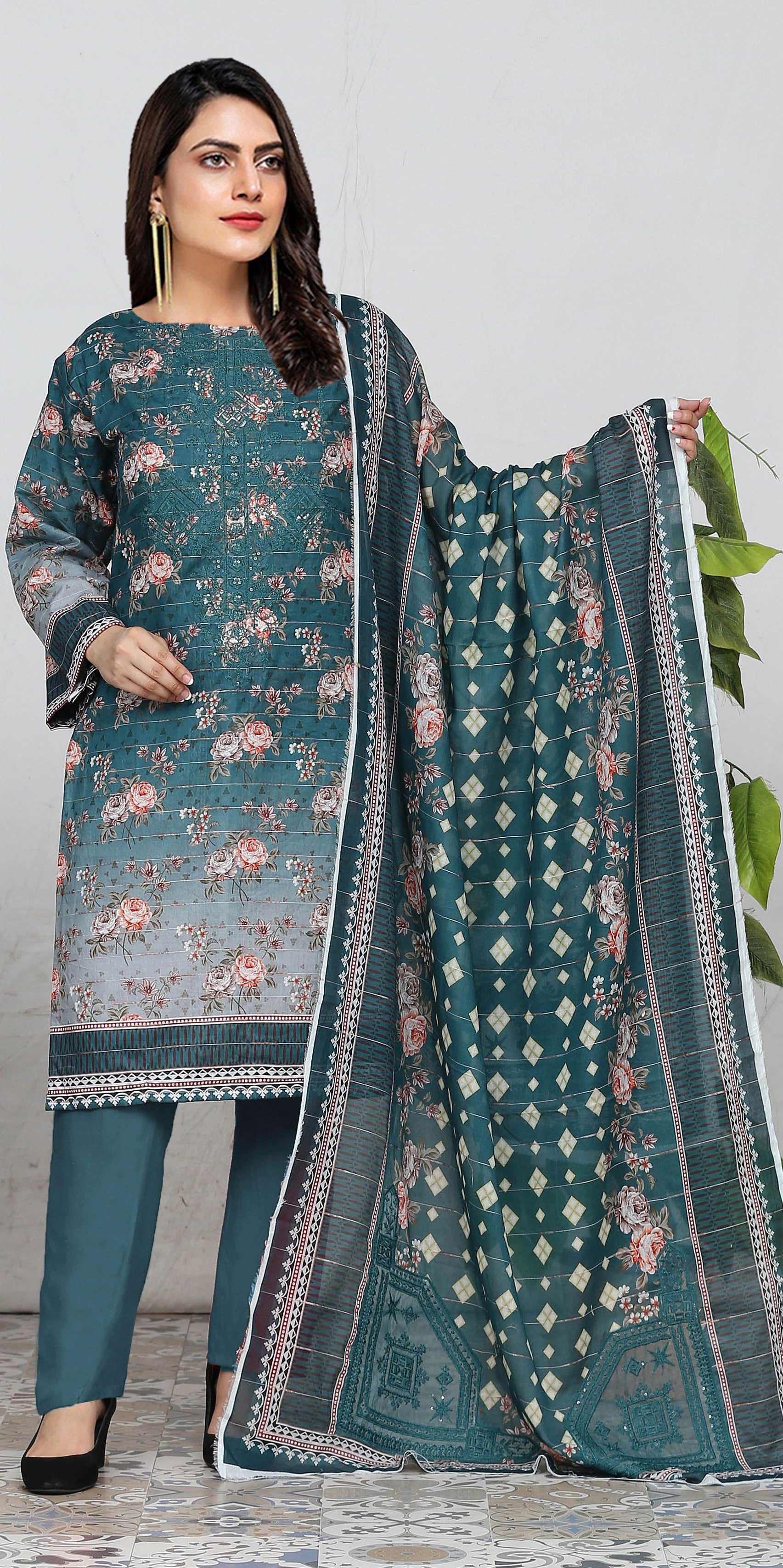 Woman wearing a teal printed outfit with a matching dupatta on a light gray background