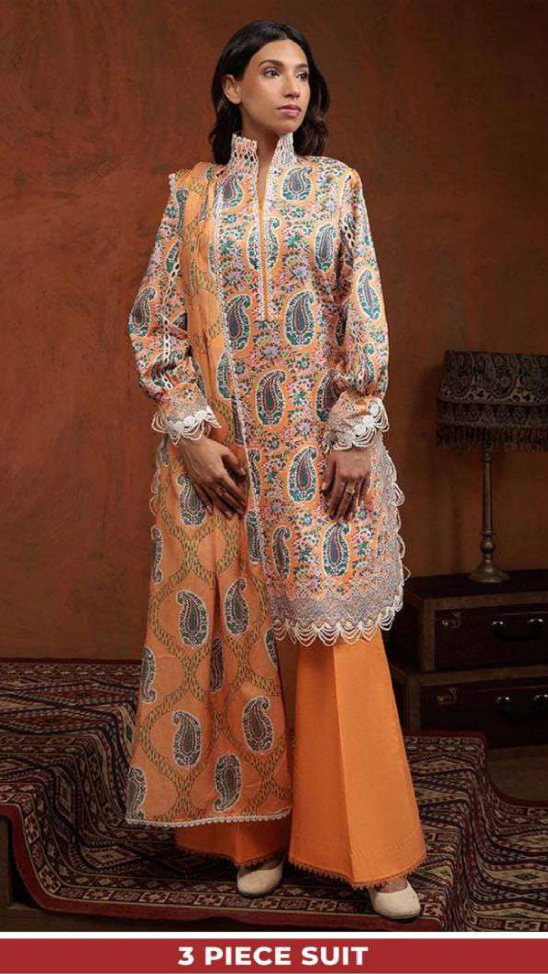 Woman wearing a three-piece suit with intricate patterns on a brown background