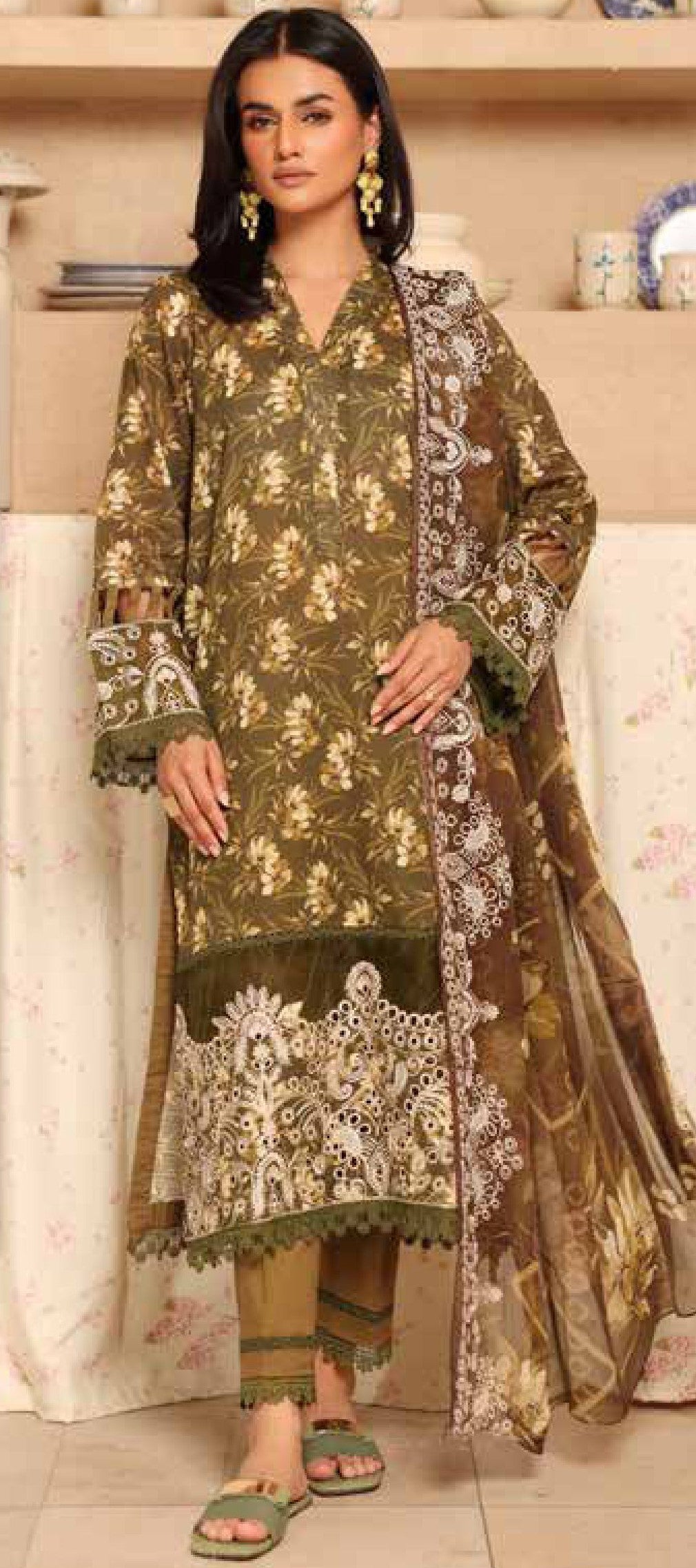 Woman wearing a traditional embroidered outfit with a brown and green color scheme.