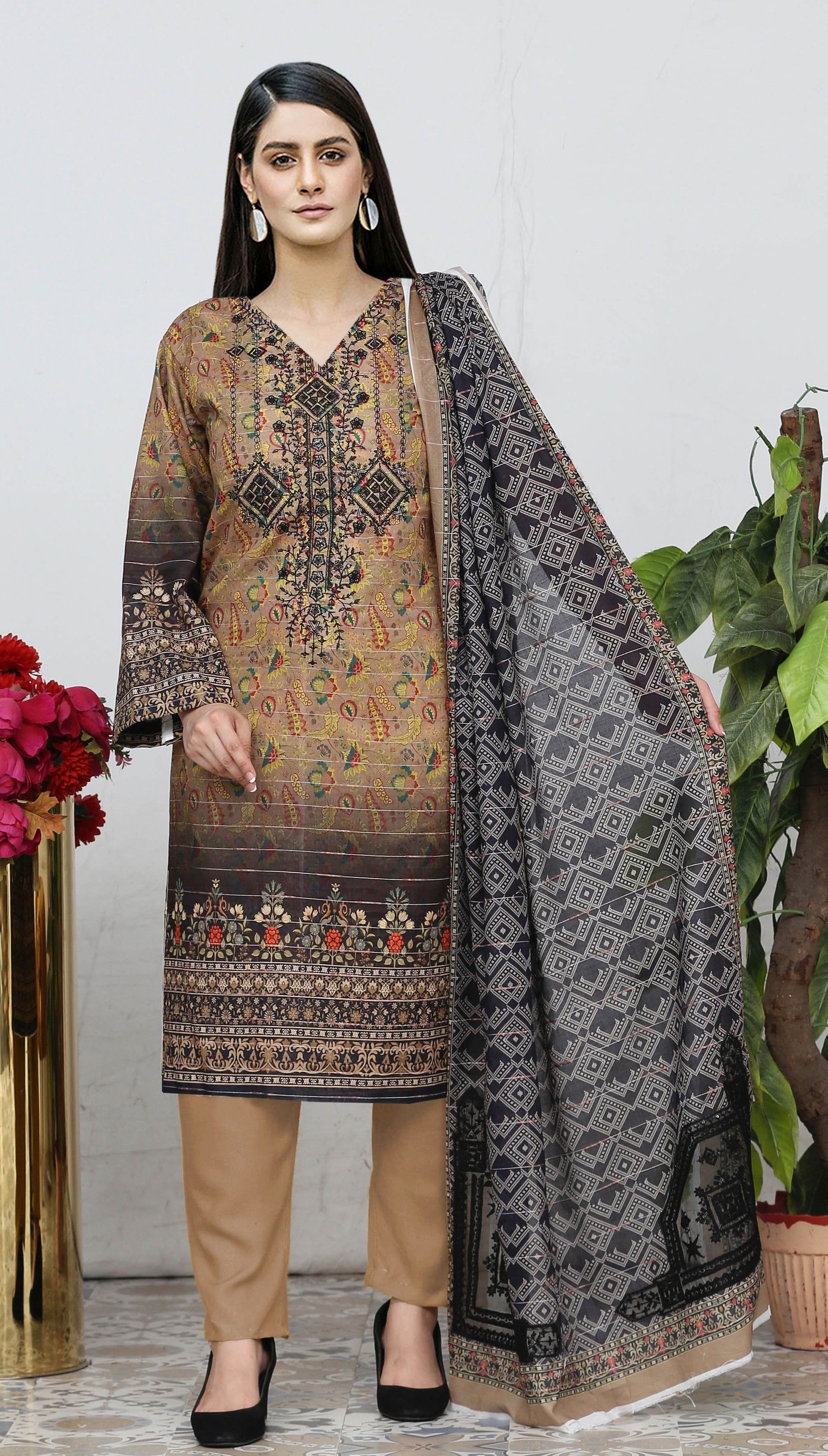 Woman wearing a traditional outfit with a patterned shirt, dupatta, and pants against a white background.