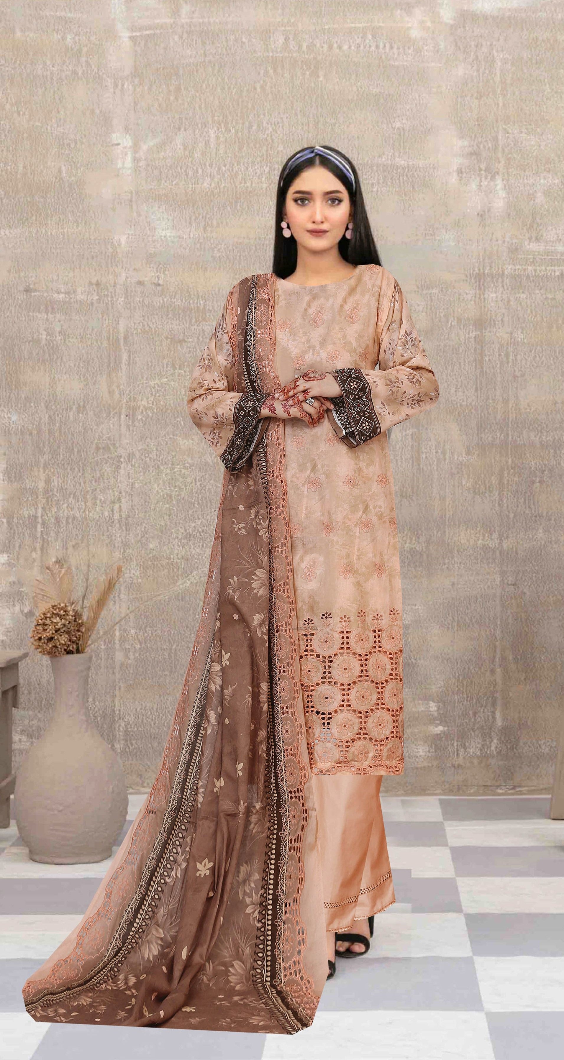 Woman wearing a traditional outfit with intricate patterns in a room with a checkered floor.