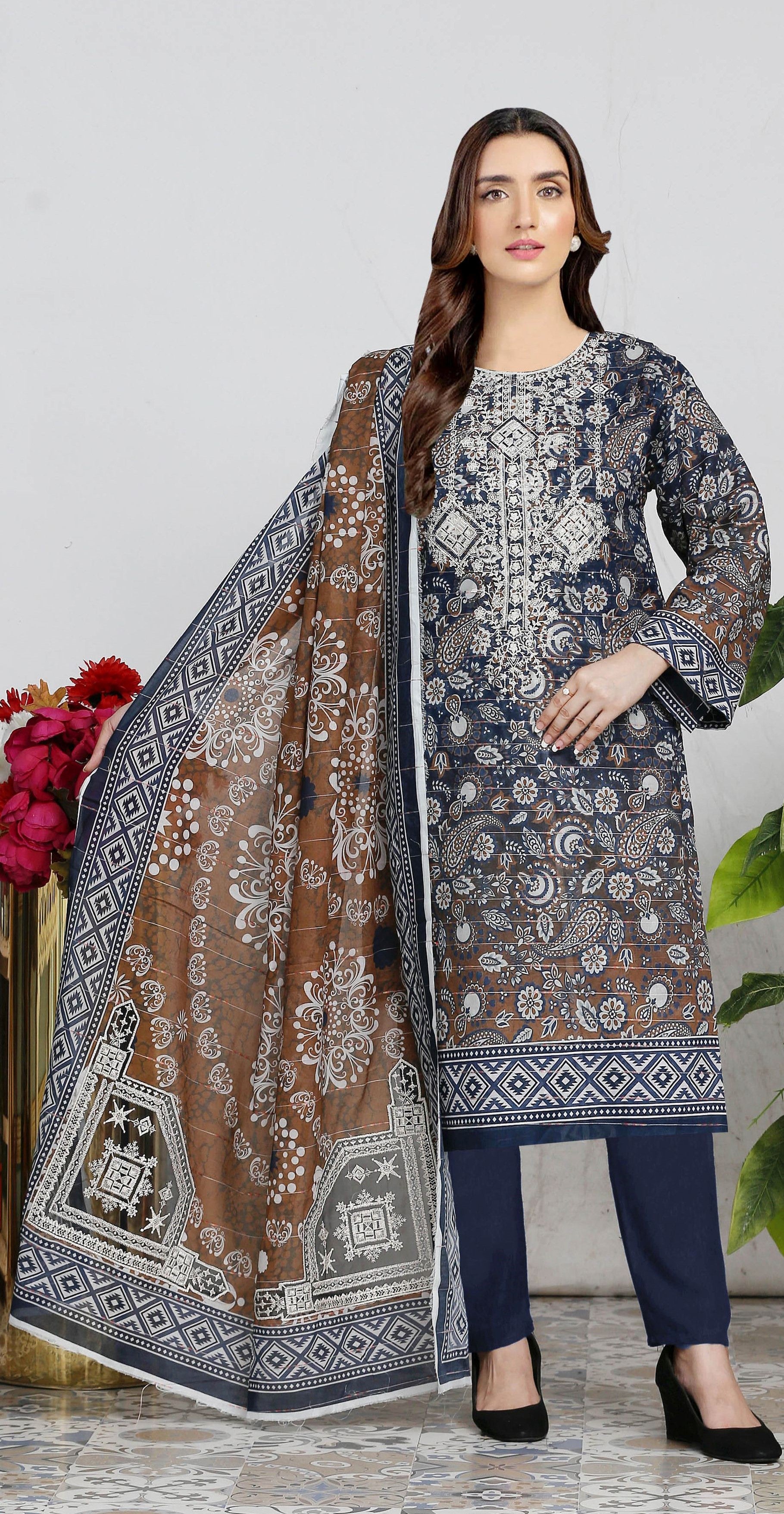 Woman wearing a traditional outfit with a patterned dupatta against a white background