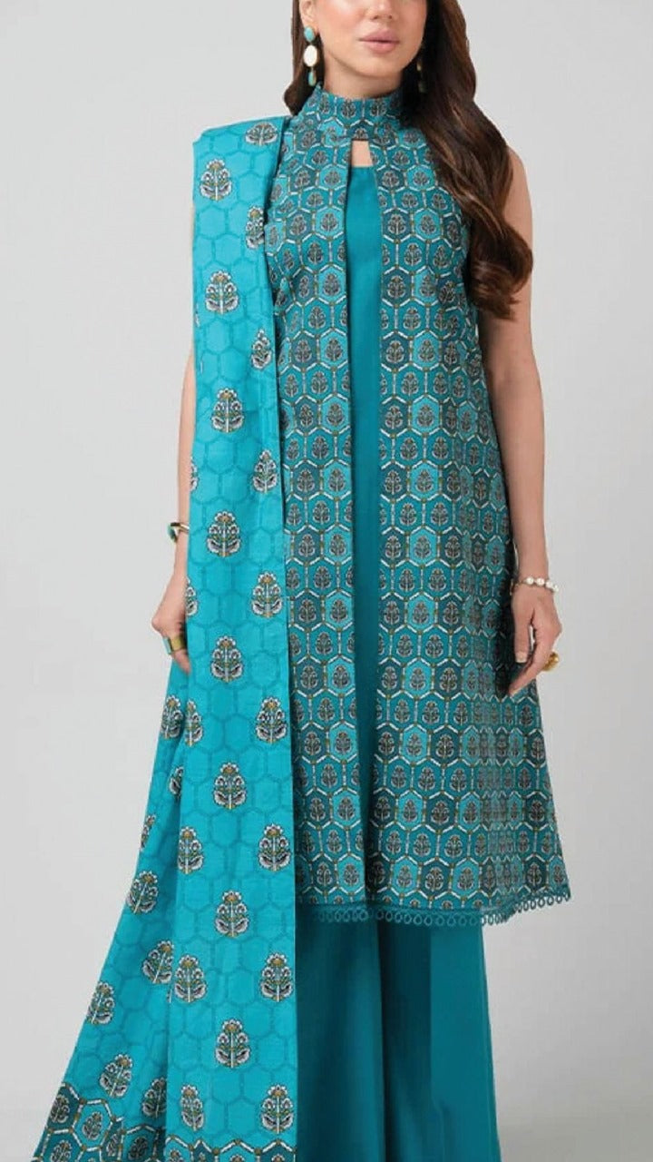 Woman wearing a turquoise printed outfit with a matching dupatta on a gray background