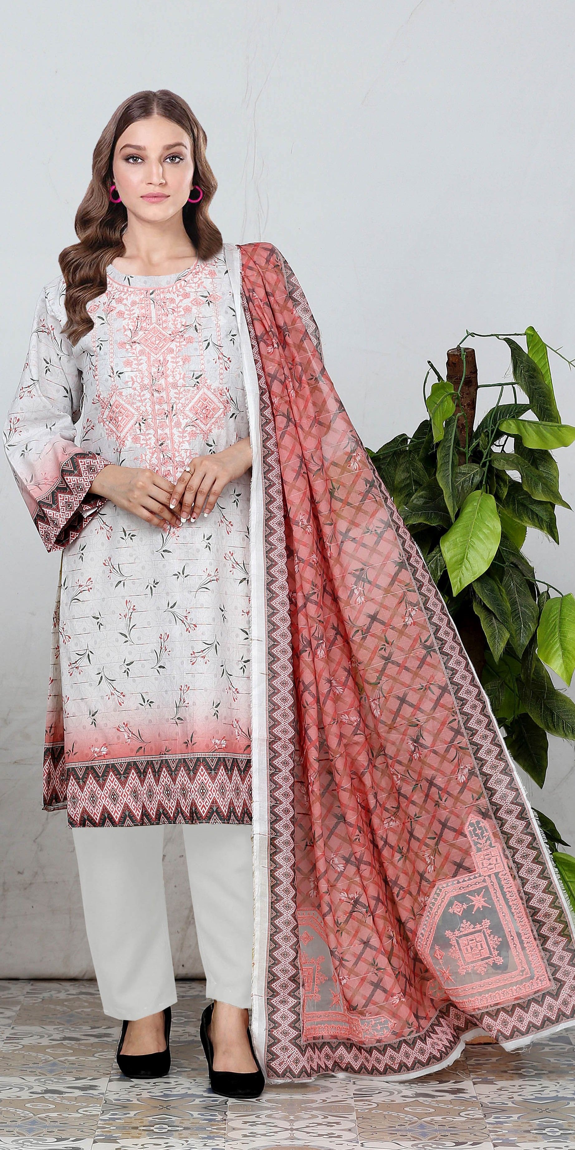 Woman wearing a white and pink traditional outfit with a plant in the background
