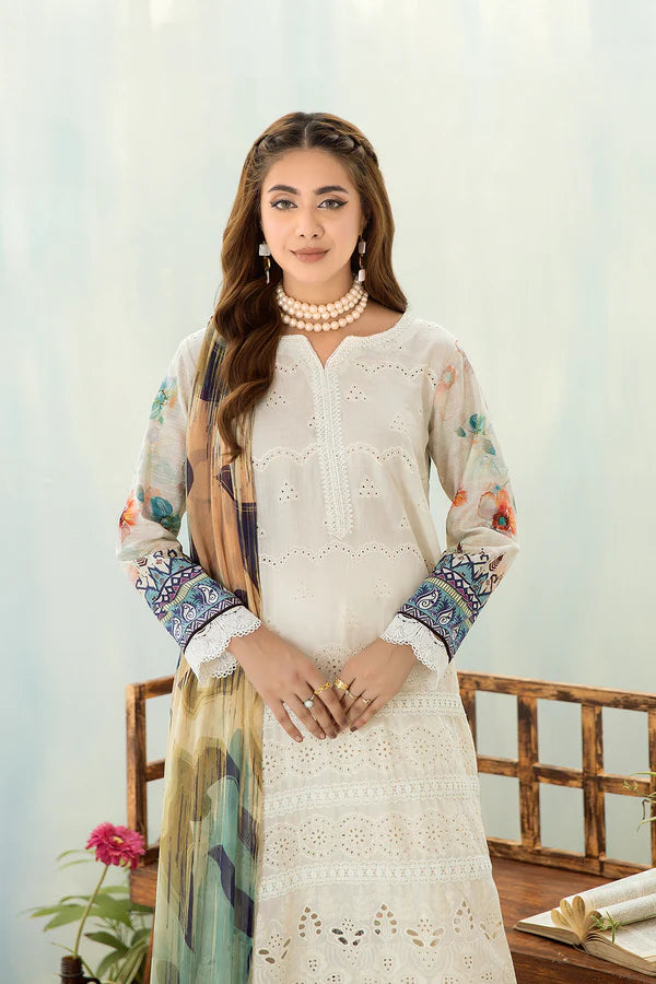 Woman wearing a white embroidered outfit with colorful sleeves against a light background