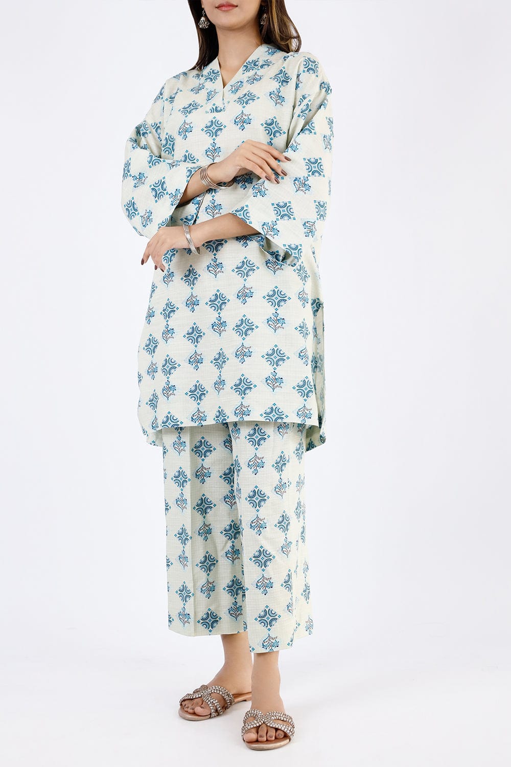 Woman wearing a white outfit with blue floral patterns on a white background