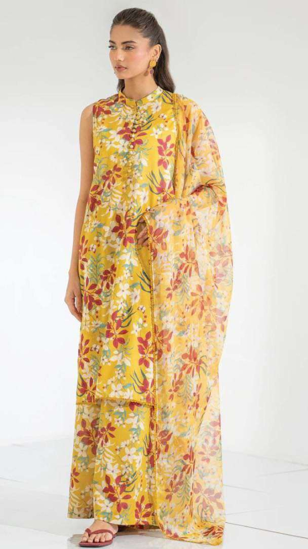 Woman wearing a yellow floral dress on a white background