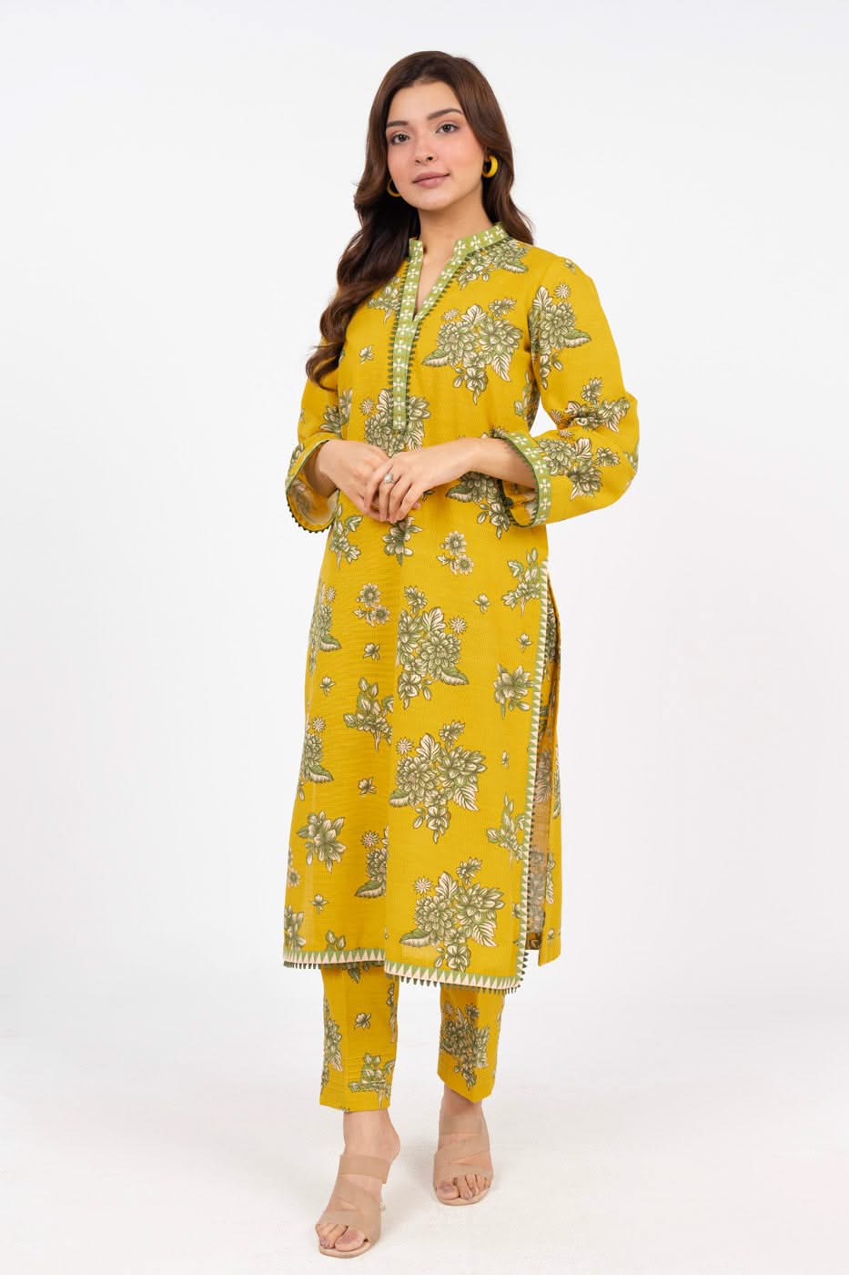 Woman wearing a yellow embroidered outfit on a white background