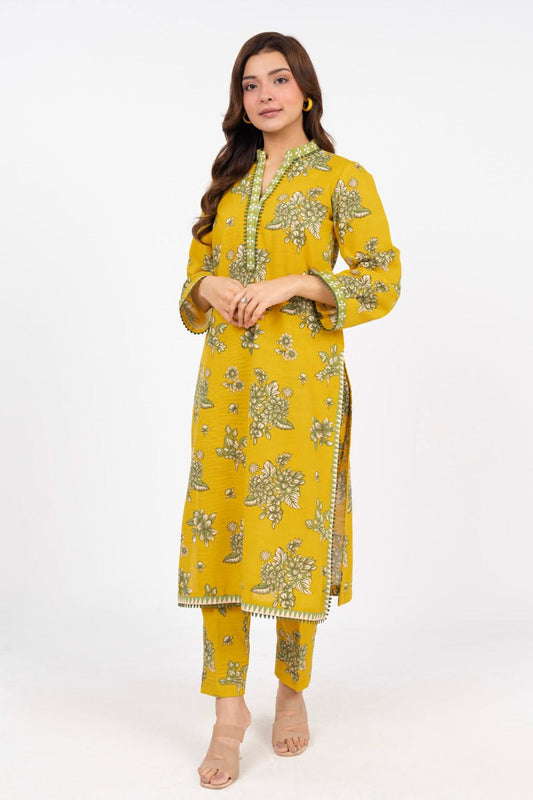 Woman wearing a yellow embroidered outfit on a white background