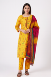 Woman wearing a yellow traditional outfit with a pink dupatta on a white background