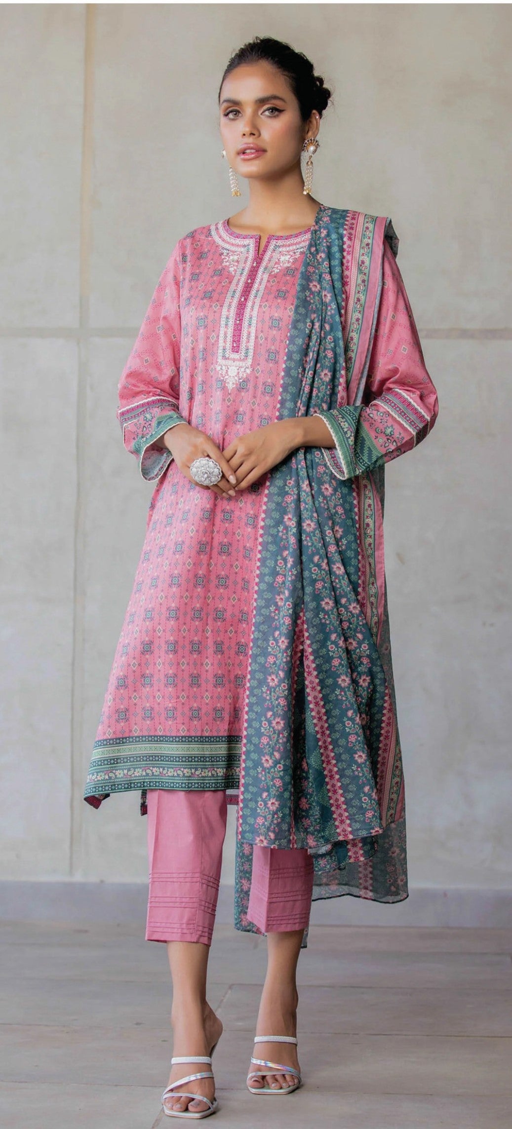 Woman wearing a zeen pink and green traditional outfit with a plain background