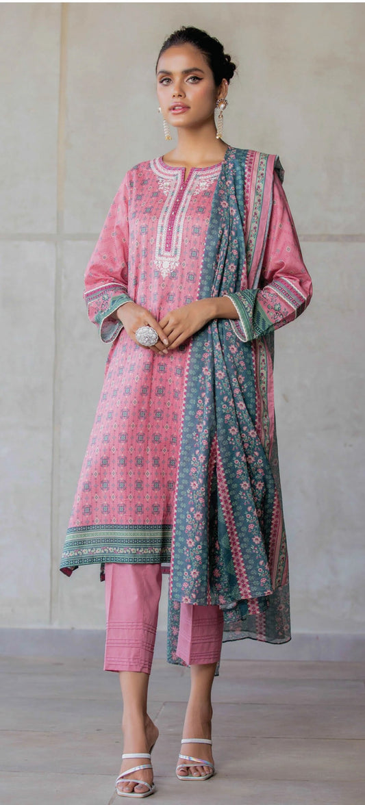Woman wearing a zeen pink and green traditional outfit with a plain background