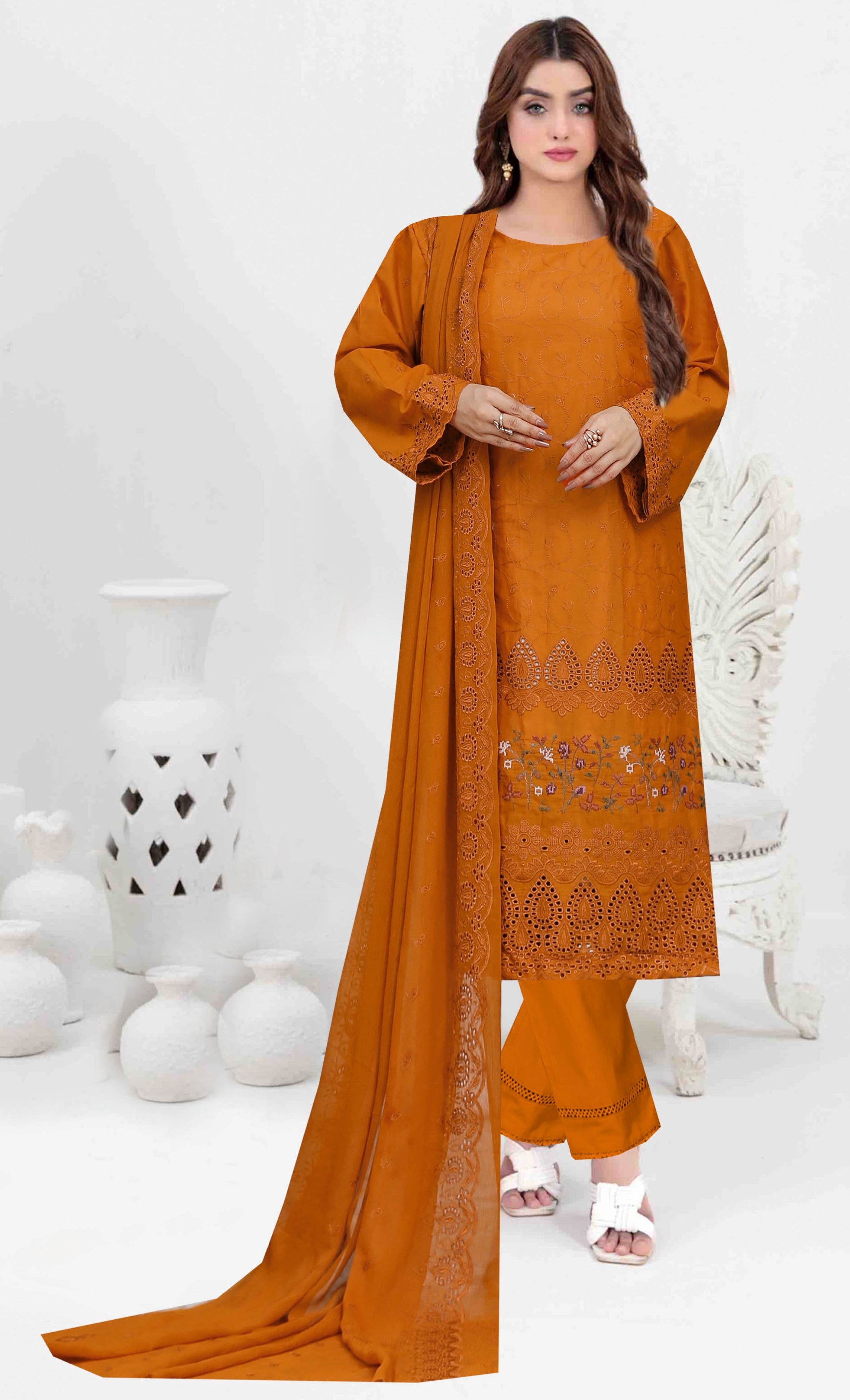 Woman wearing an mustard embroidered outfit with a matching dupatta on a white background
