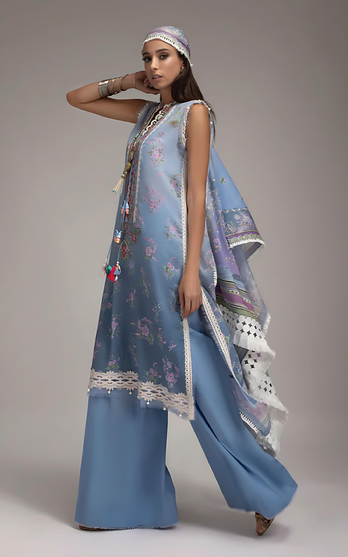 Woman wearing sobia nazir a light blue traditional outfit with a matching dupatta on a gray background