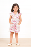 Young girl wearing a floral dress on a white background