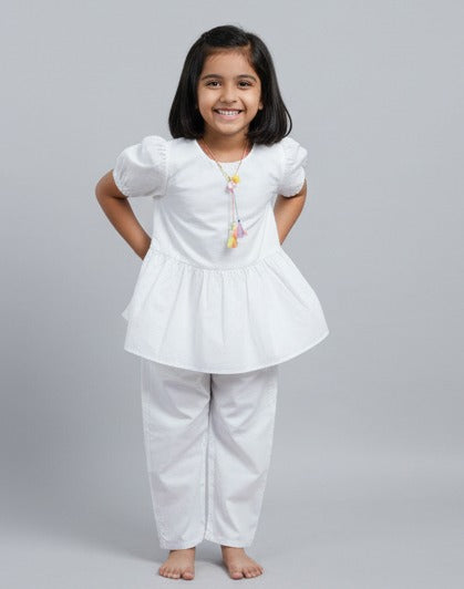 Young girl wearing a white outfit with puffed sleeves on a gray background