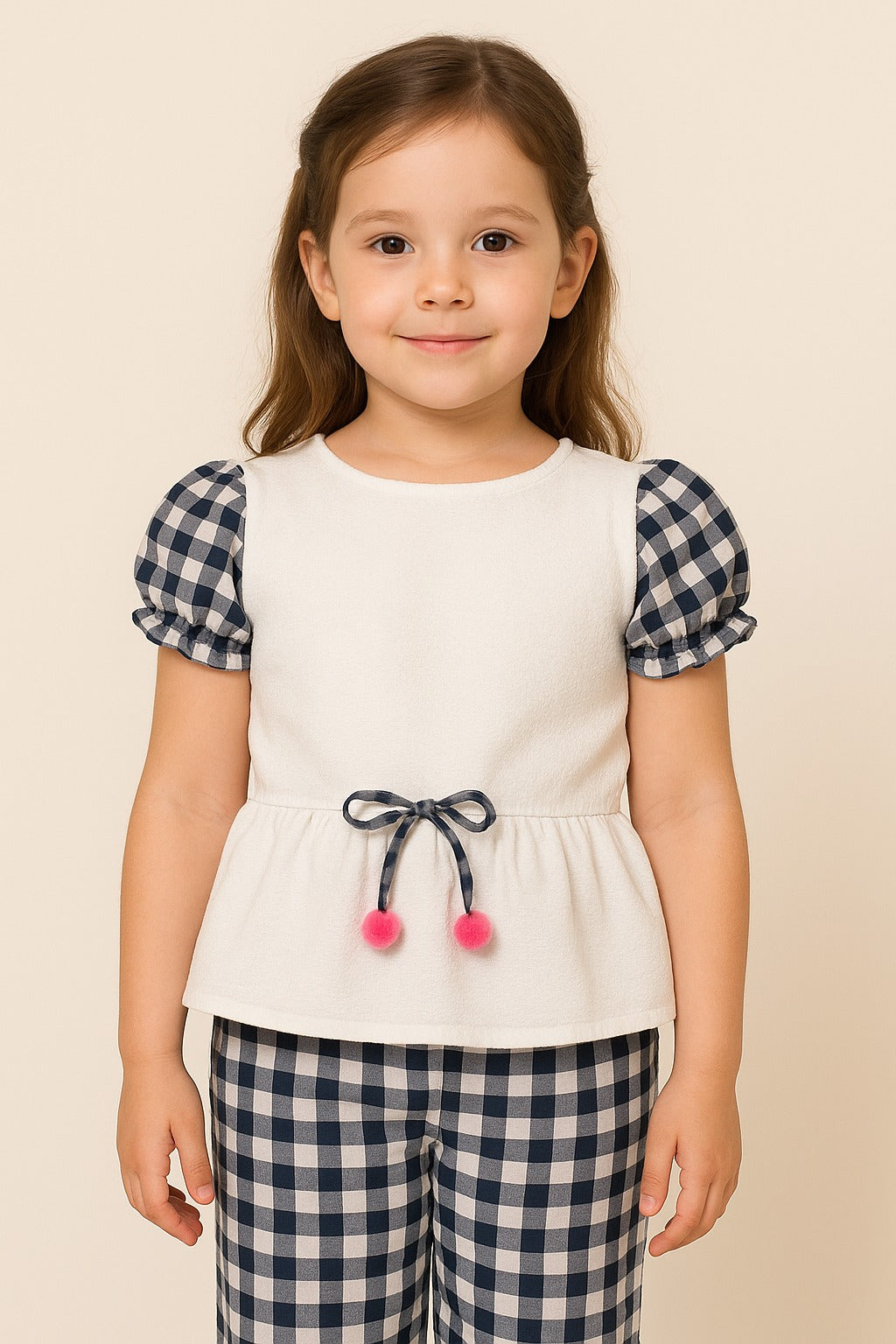Young girl wearing a white top with checkered sleeves and plaid pants on a beige background