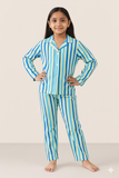 Young girl wearing blue and green striped pajamas on a white background