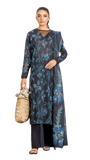 Woman wearing a long dark dress with blue floral patterns on a white background